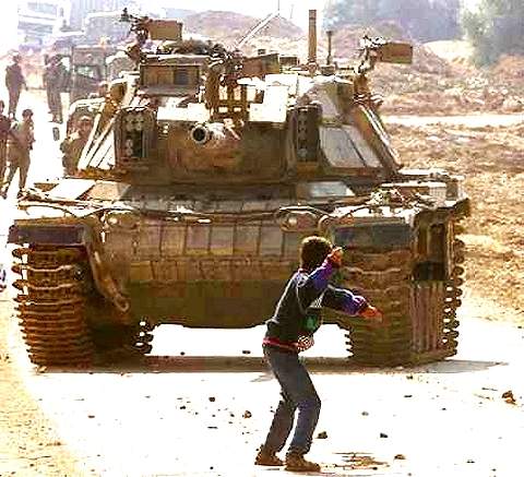 Palestijnse jongen die stenen gooit naar een Israelische tank