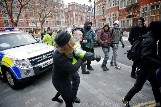 a police officer punches a protestor for not getting out of his way